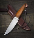 Hunting knife handmade on a brown wooden background. Leather Sheath Handmade