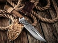 Hunting Knife with leather sheath on a wooden table.