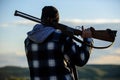 Hunting masculine hobby leisure concept. Brutality and masculinity. Hunter carry rifle gun on shoulder rear view. Guy Royalty Free Stock Photo