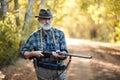 Hunting and people concept - close up of senior hunter holding shotgun