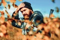 Hunting Poacher in the Forest. Hunter with shotgun gun on hunt. Hunting Gear and Hunting Clothing. Close up Portrait of