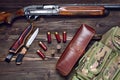 Hunting rifle and ammunition on a wooden background.