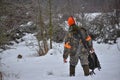 Hunting season, bird hunting. The hunter is on the snow pick up a bird he brought down