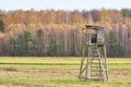 Hunting tower in a field with autumnal forest in background Royalty Free Stock Photo