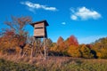 Hunting tower in wild forest. Wooden Hunter Hide High watch post tower. Hunter`s observation point in forest in Europe