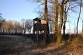 Hunting watchtower on a meadow, sunny winter afternoon.