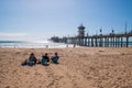 Huntington Beach, California - October 11, 2018: Three woman sitting on chairs on a deserted beach talking and looking at a long