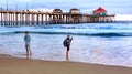 Huntington Beach Pier at Sunset with Two People Standing on Shore Royalty Free Stock Photo