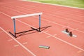 Hurdle, relay baton and a starting block kept on a running track Royalty Free Stock Photo