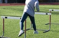 Hurdle runner perfoeming the trail leg drill on a turf field