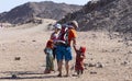 Bedouin children entertain tourists. Kids of the Sahara desert. Children-natives extort gifts from tourists