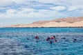 Hurghada, Egypt - December 3, 2018: group of people, adults and children, with diving masks and snorkels swimming underwater in Royalty Free Stock Photo