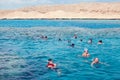 Hurghada, Egypt - December 3, 2018: group of people, adults and children, with diving masks and snorkels swimming underwater in Royalty Free Stock Photo