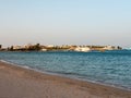 Hurghada, Egypt - September 22, 2021: Sandy beach of the red sea at sunset. Yachts and boats stand near the pier, tourists return Royalty Free Stock Photo