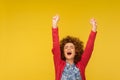 Hurray, I am champion! Portrait of ecstatic happy woman with curly hair shouting joyfully and raising hands