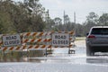 Hurricane flooded street with road closed signs blocking driving of cars. Safety of transportation during natural Royalty Free Stock Photo