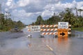 Hurricane flooded street with road closed signs blocking driving of cars. Safety of transportation during natural Royalty Free Stock Photo