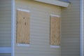 Hurricane shutters made from plywood mounted for protection of house windows. Protective measures before natural Royalty Free Stock Photo