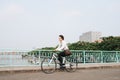 Hurry Asian businessman riding bike in rush hour. Young man late for train work, meeting.