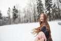 Hurry up please. Girl with long hair goes near the forest to the automobile in wintertime Royalty Free Stock Photo