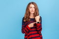 Hurry up, it& x27;s late. Portrait of nervous woman wearing striped casual style sweater pointing at