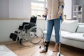 Hurt Leg Using Crutches Near Wheelchair