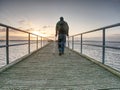 Hurt man with hooded jacket and forearm crutches looking sadly