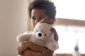 Hurt small biracial boy hold toy feeling lonely Royalty Free Stock Photo