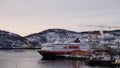 Hurtigruten ship docked at Harstad city harbour at sunrise in winter in Northern Norway Royalty Free Stock Photo