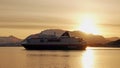 Hurtigruten ship leaving Harstad city harbour at sunrise in winter in Northern Norway Royalty Free Stock Photo