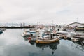 boats reflected in calm water of harbour husavik iceland