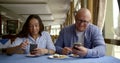 Husband bald and glasses and dark-haired middle-aged wife, sitting in a cafe, eat, communicate. They have on the table