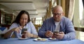 Husband bald and glasses and dark-haired middle-aged wife, sitting in a cafe, eat, communicate. They have on the table