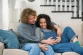 Husband touching pregnant tummy of his charming joyful wife which lying on the couch in cozy living room Royalty Free Stock Photo