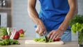 Husband cutting fresh salad on board for healthy family lunch, cooking help Royalty Free Stock Photo