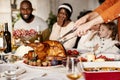 Close-up happy young men and women, married couple celebrate Thanksgiving day. Family dinner with roasted turkey Royalty Free Stock Photo