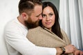 Husband embraces his wife and sheltering blanket