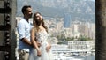 Husband embraces wife in background of city. Action. Young beautiful couple embracing on cityscape background. Newlyweds