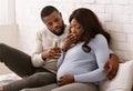 Husband giving his sick pregnant wife glass of water