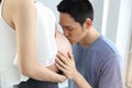 Husband giving kiss to young pregnant belly wife with love Royalty Free Stock Photo