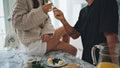 Husband hands feeding woman with berries at white interior. Romantic pair eating