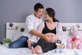 Husband and his pregnant wife showing heart with hands in bed Royalty Free Stock Photo