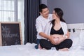 Husband and his pregnant wife showing heart with hands in bed Royalty Free Stock Photo