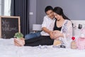 Husband and his pregnant wife showing heart with hands in bed Royalty Free Stock Photo