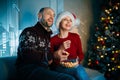 A husband and his wife enjoy popcorn on Christmas eve and laughing loudly while watching movies Royalty Free Stock Photo