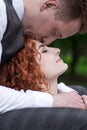 The husband kisses his wife on the forehead. A young couple. Happy redhead husband and wife. Royalty Free Stock Photo