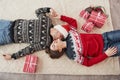 Husband kissing his wife. Top view of couple in Christmas clothes lies on the floor with gifts on it