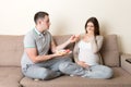 Husband offers donuts to his pregnant wife but she refuses and makes stop gesture because she feels sick. Feeling bad during