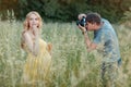 Husband photographs the pregnant wife in a field