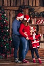 Husband, pregnant wife and daughter hold a Christmas costume for the baby.